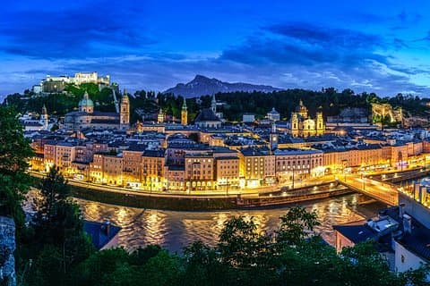 A breathtaking view of Salzburg from Kapuzinerberg, with the Untersberg rising behind the city and its iconic fortress. The Salzach River and Salzburg’s many churches complete this stunning scene.