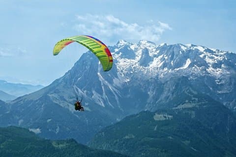 Tandem paragliding above the Austrian Alps near Salzburg, offering spectacular panoramic views of rugged peaks and wide valleys from one of the region’s most scenic launch sites.