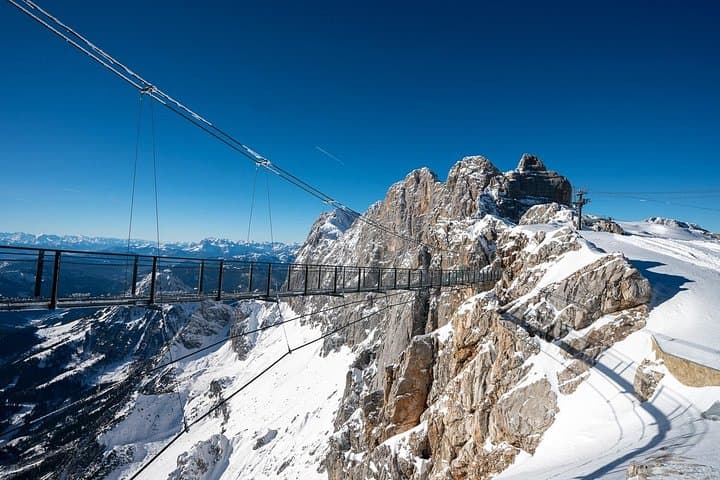 The Roof of Styria: Conquer the incredible suspension bridge leading to the Dachstein summit station, surrounded by endless Alpine peaks.
