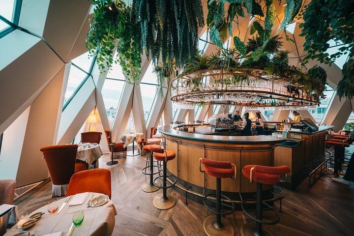 End the night in a stunning rooftop bar with skyline views and lush, modern design.