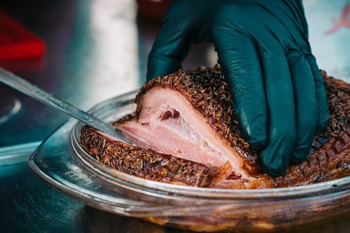 Slicing into juicy roast pork seasoned with aromatic caraway seeds.