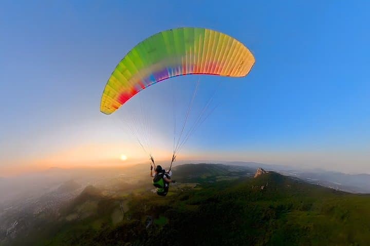 Tandem paragliding above Salzburg in golden evening light, offering sweeping views of the city, rolling hills and alpine horizons from a spectacular bird’s-eye perspective.