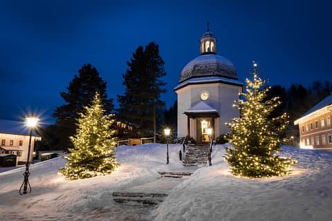 Here’s an updated caption:
Silent Night Chapel illuminated on a snowy night, creating a romantic and serene winter atmosphere near Salzburg.