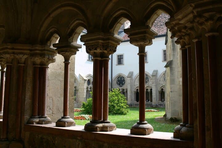 Tranquil Courtyards: Look out through intricate Gothic arches into the beautifully manicured monastery gardens.