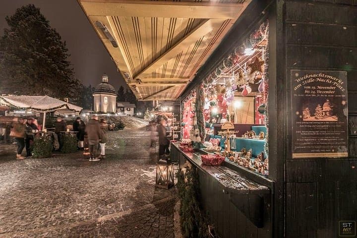 Festive Christmas market in front of the Silent Night Chapel, creating a charming holiday atmosphere near Salzburg.