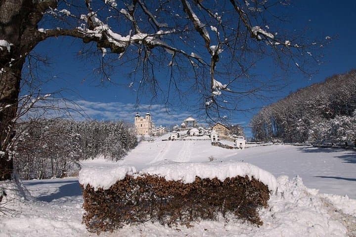 Maria Plain pilgrimage church perched on a snowy hill under a clear blue sky, offering breathtaking winter views near Salzburg.