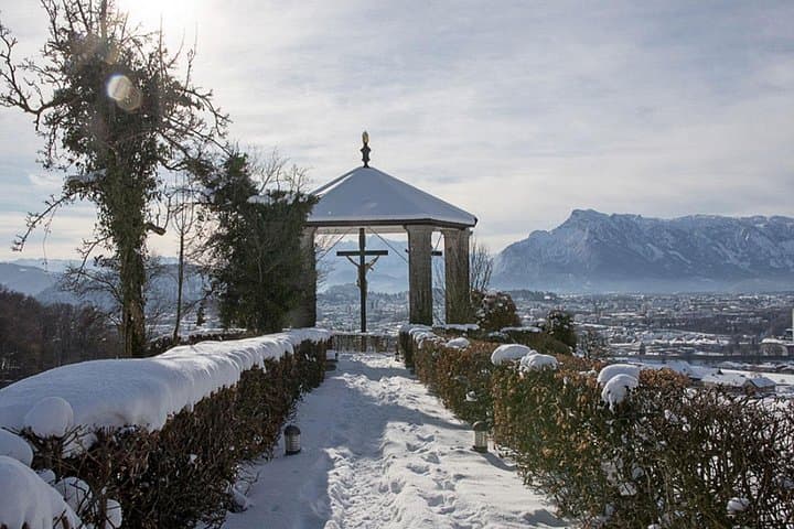 Panoramic winter view from Maria Plain overlooking the city of Salzburg and the snow-covered mountains beyond, set in a breathtaking landscape.